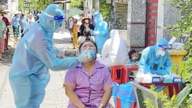 Nhân viên y tế lấy mẫu xét nghiệm Covid-19 cho người dân sống tại xã Bình Hưng, huyện Bình Chánh, TPHCM