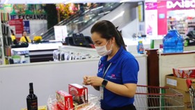 Nhân viên Co.opmart gói giỏ quà cho khách theo đơn đặt hàng online