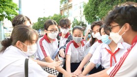 Học sinh Trường THCS Tùng Thiện Vương (quận 8) thể hiện sự quyết tâm đạt kết quả tốt môn Toán trước khi vào phòng thi. Ảnh: CAO THĂNG