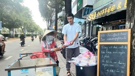 Một tuần 3 lần, quán kê chiếc bàn nhỏ phía trước, bày những túi nhỏ, mỗi túi có chai nước suối ướp lạnh, ổ bánh mì thịt