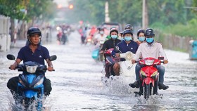 Vào tháng 10, tháng 11 âm lịch hàng năm, triều cường thường gây ngập đường Trần Xuân Soạn (quận 7, TPHCM). Ảnh: HOÀNG HÙNG