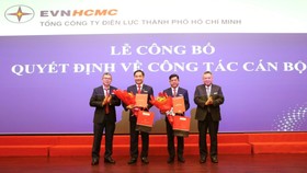 Ông Bùi Hải Thành và ông Nguyễn Thanh Nhã nhận quyết định và hoa chúc mừng từ Chủ tịch EVNHCMC Phạm Quốc Bảo (bìa phải) và Tổng Giám đốc EVNHCMC Nguyễn Văn Thanh (bìa trái)