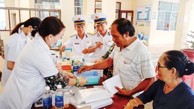 Các y, bác sĩ Vùng 2 Hải quân phối hợp với Bệnh viện Lê Văn Thịnh thăm khám, tư vấn sức khỏe và cấp thuốc miễn phí cho ngư dân xã Bình Châu