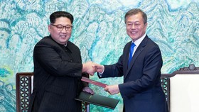 Chủ tịch Kim Jong Un và Tổng thống Moon Jae In ký văn bản sau hội đàm ngày 27-4. Ảnh: REUTERS