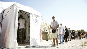 Người di cư xếp hàng chờ xét nghiệm virus SARS-CoV-2 ở trại tị nạn Moria trên đảo Lesbos, Hy Lạp. Ảnh: AP
