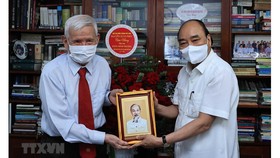 Chủ tịch nước Nguyễn Xuân Phúc thăm nhà báo Đặng Minh Phương. Ảnh: TTXVN