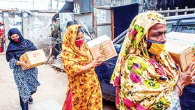 Phụ nữ Bangladesh nhận hàng cứu trợ của Chương trình Phát triển Liên hiệp quốc (UNDP) trong đại dịch Covid-19