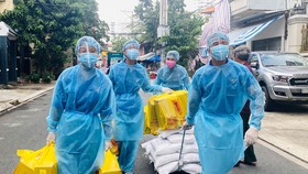 Đoàn viên thanh niên khu phố 1, phường Hòa Thạnh, quận Tân Phú đưa nhu yếu phẩm vào khu phong tỏa, trao tận tay người dân. Ảnh: VŨ TÂN