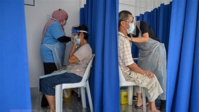 Nhân viên y tế tiêm vaccine phòng Covid-19 cho người dân tại Kuala Lumpur, Malaysia. Ảnh: TTXVN
