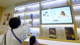 Quét mã QR để chọn sách đa phương tiện tại một hiệu sách ở Hàng Châu, Trung Quốc