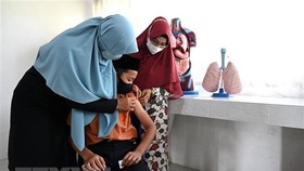 Nhân viên y tế tiêm vaccine phòng Covid-19 cho học sinh tại Indonesia. Ảnh: TTXVN