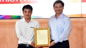 Phó Chủ tịch Thường trực UBND tỉnh Thừa Thiên - Huế Nguyễn Thanh Bình (bên phải) trao Thư khen của Chủ tịch nước cho anh Tô Vũ Đồng. Ảnh: NDO