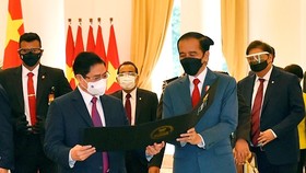 Tổng thống Indonesia Joko Widodo thân tặng Thủ tướng Phạm Minh Chính tấm hình kỷ niệm cuộc gặp đầu tiên trên cương vị Thủ tướng. Ảnh: VGP