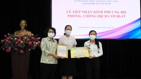 Đại diện Ủy ban MTTQ Việt Nam TPHCM tiếp nhận ủng hộ của Công ty JOY qua sự kết nối của Báo SGGP