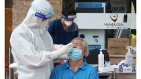 Nhân viên y tế Bệnh viện Đa khoa Quốc tế Nam Sài Gòn lấy mẫu  xét nghiệm cho người dân.  Ảnh: HOÀNG HÙNG