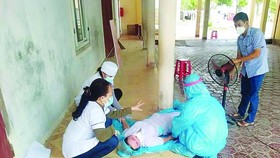 Các đồng nghiệp sơ cứu chị Nguyễn Thị Hương bị ngất xỉu. Ảnh: DƯƠNG QUANG