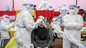 Nhân viên y tế lấy mẫu xét nghiệm Covid-19 cho người dân tại Jakarta, Indonesia. Ảnh: AFP