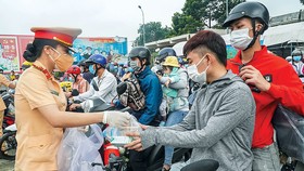 Công an Đồng Nai phát thức ăn, nước uống cho người lao động trên đường về quê.