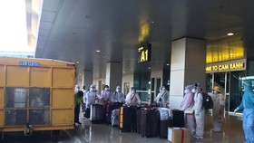 Công dân Việt Nam từ nước ngoài trở về chuẩn bị rời sân bay Cam Ranh đến khu cách ly tập trung. (Ảnh: Phan Sáu/TTXVN)