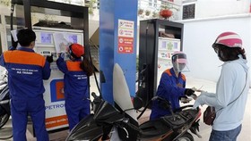 Mua bán xăng dầu sau khi điều chỉnh giá bán tại cửa hàng kinh doanh xăng dầu Petrolimex. (Ảnh: Trần Việt/TTXVN)