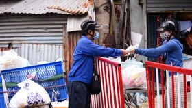 Shipper giao hàng cho khách tại chốt ở quận Phú Nhuận (TP.HCM) vào trưa 2-9 - Ảnh: QUANG ĐỊNH