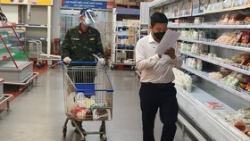 Cán bộ phường cùng bộ đội đi chợ giúp người dân ở siêu thị tại TP Thủ Đức - Ảnh: MINH HÒA