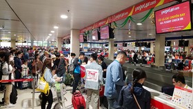 Việc áp giá sàn khiến người tiêu dùng mất cơ hội chọn vé máy bay giá rẻ. Trong ảnh, người dân làm thủ tục tại sân bay Tân Sơn Nhất vào dịp tết - Ảnh: NGỌC HIỂN