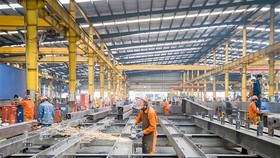 Công nhân lao động Công ty cổ phần Cơ khí xây dựng thương mại Đại Dũng tại khu Công nghiệp An Hạ, huyện Bình Chánh. (Ảnh: Thanh Vũ/TTXVN)