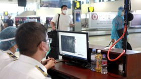 Kiểm tra thân nhiệt tự động khách đi máy bay tại sân bay Nội Bài - Ảnh: TUẤN PHÙNG