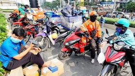 Các tài xế xe công nghệ tất bật ngày Tết giao hàng và chở khách - Ảnh: C.TRUNG