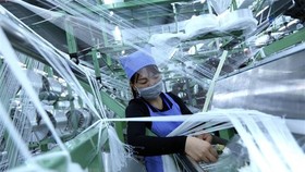 Dây chuyền sản xuất vải dệt kim tại doanh nghiệp có vốn đầu tư của Hồng Kong (Trung Quốc) tại khu công nghiệp VSIP ở Hải Dương. (Ảnh: Danh Lam/TTXVN)