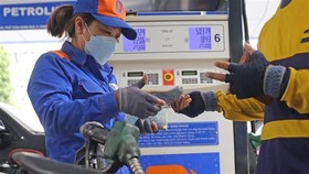 Người dân mua xăng dầu tại một cửa hàng của Petrolimex. (Ảnh: Trần Việt/TTXVN)