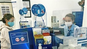 Khách hàng giao dịch tại Ngân hàng TMCP Quốc Dân. (Ảnh: Trần Việt/TTXVN)