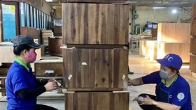Công nhân Công ty Cổ phần Chế biến gỗ Thuận An kiểm tra các sản phẩm gỗ xuất khẩu. (Ảnh: TTXVN)