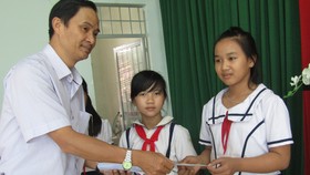 Ông Trần Văn Phong, Trưởng Văn phòng đại diện báo SGGP khu vực Đông Nam bộ tặng học bổng cho học sinh