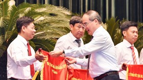 Đồng chí Nguyễn Thiện Nhân, Bí thư Thành ủy TPHCM, trao cờ thi đua chính phủ cho các tập thể.  Ảnh: VIỆT DŨNG
