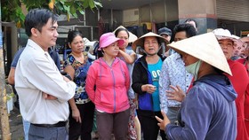 Ông Lê Thanh Bình (bìa trái) lúc còn là Phó Chủ tịch UBND quận Tân Bình đang lắng nghe ý kiến của tiểu thương chợ Tân Trụ (phường 15) khi quận xử lý lấn chiếm vỉa hè, lòng đường. Ảnh: KIỀU PHONG 