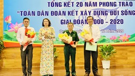 Phó Chủ tịch UBND quận 7 Bùi Thị Ngọc Hiếu (thứ 2, từ trái sang), tặng hoa cho đại diện các đơn vị có thành tích tốt trong thực hiện phong trào “toàn dân đoàn kết xây dựng đời sống văn hóa”. Ảnh: HOÀNG MINH