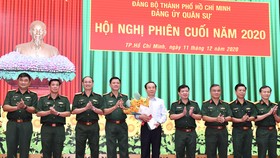 Bí thư Thành ủy TPHCM Nguyễn Văn Nên nhận hoa chúc mừng giữ chức vụ Bí thư Đảng ủy Quân sự TPHCM, sáng 11-12-2020. Ảnh: VIỆT DŨNG