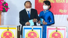 Chủ tịch nước Nguyễn Xuân Phúc và phu nhân bỏ phiếu bầu đại biểu Quốc hội (ĐBQH) khóa XV và ĐB HĐND các cấp nhiệm kỳ 2021-2026. Ảnh: VIỆT DŨNG