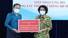 Chủ tịch Ủy ban MTTQ Việt Nam TPHCM Tô Thị Bích Châu tiếp nhận bảng tượng trưng ủng hộ do tỉnh Attapeu, Lào trao tặng