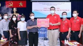 Phó Chủ tịch Ủy ban MTTQ Việt Nam TPHCM Phạm Minh Tuấn tiếp nhận bảng tượng trưng ủng hộ từ nhà tài trợ