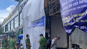 Thực nghiệm hiện trường vụ cháy chi nhánh ngân hàng Eximbank cùng nhà dân ở quận Gò Vấp. Ảnh: CHÍ THẠCH 