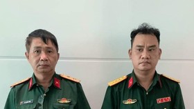Võ Thành Phúc và Trần Vũ Hàn Minh Nhật (từ trái qua phải) cùng trang phục Quân đội tại cơ quan công an 