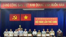 Đồng chí Nguyễn Hữu Hiệp, Trưởng Ban Dân vận Thành ủy TPHCM trao tặng bằng khen của Thành ủy TPHCM cho các tổ chức đảng và đảng viên có thành tích xuất sắc trong công tác phòng, chống dịch Covid-19. Ảnh: CHÍ THẠCH