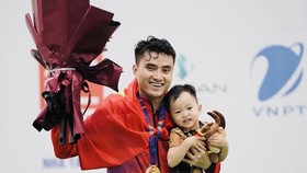 VĐV Vũ Thành An ăn mừng kết quả HCV ngày đầu tiên thi đấu tại SEA Games 31 cùng con trai. Ảnh: ĐỖ TRUNG