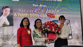 Đại diện Ban chấp hành Hội Nhà văn TPHCM, nhà văn Bích Ngân (phải) và nhà văn Trầm Hương trao tặng hoa cho nhà văn Kim Quyên như một lời chúc mừng gửi đến bà