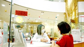 Making a transaction in a bank in HCMC. (Photo: SGGP)