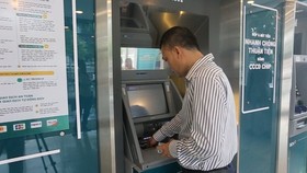 A cardholder is experiencing the use of a chip-based citizen ID card to withdraw money in Hanoi. 