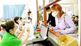 Civil employees are processing administrative documents for residents in Binh Hung Hoa A Ward People’s Committee (Binh Tan District). (Photo: SGGP)